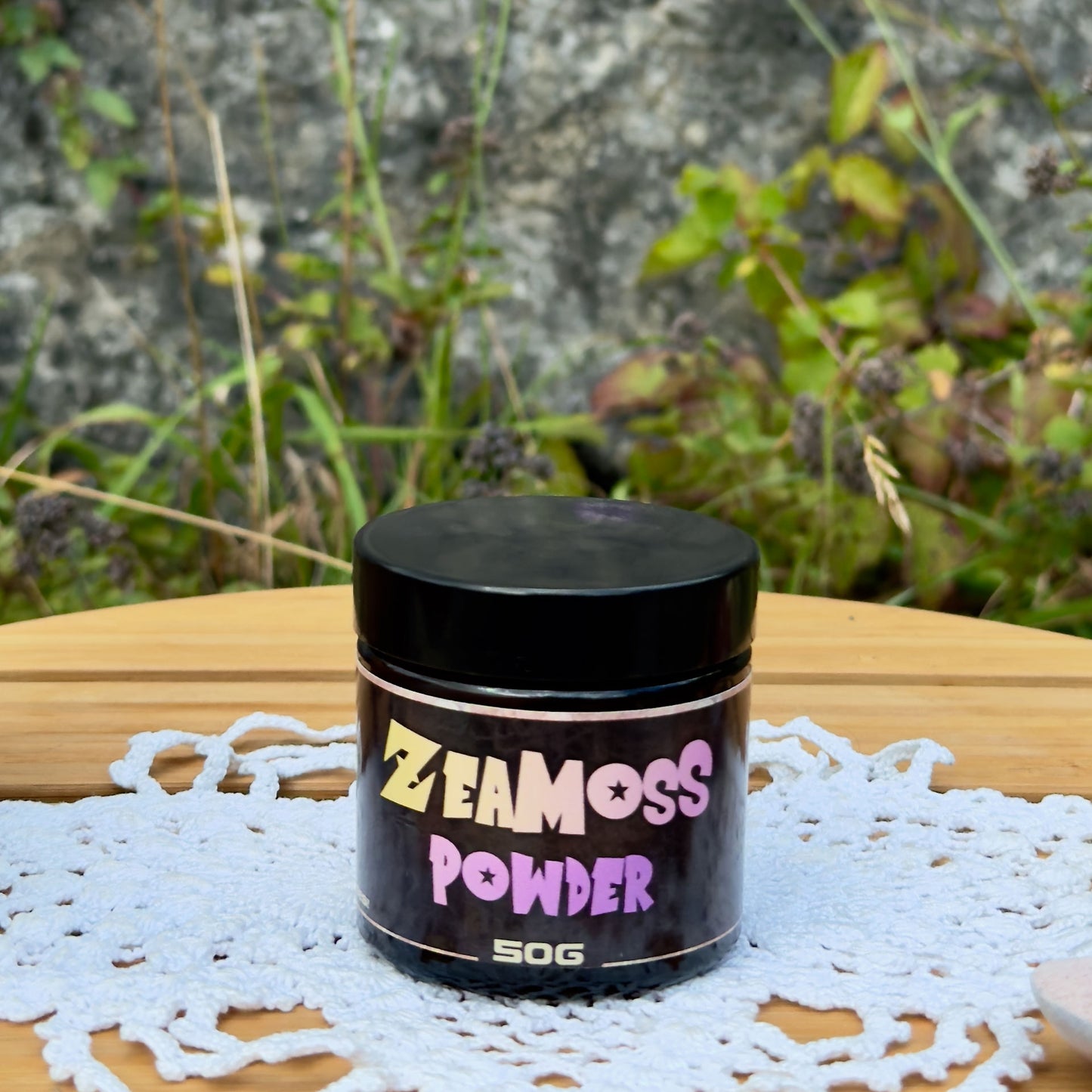 Rainbow Wildcrafted African Sea Moss Pulver (Euchema Denticulatum), 50g Glas von ZeaMoss, Closeup Bild, präsentiert draußen vor einer Naturkulisse
